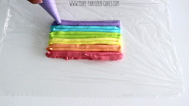 piping different colors of buttercream to create an icing plug for rainbow frosting