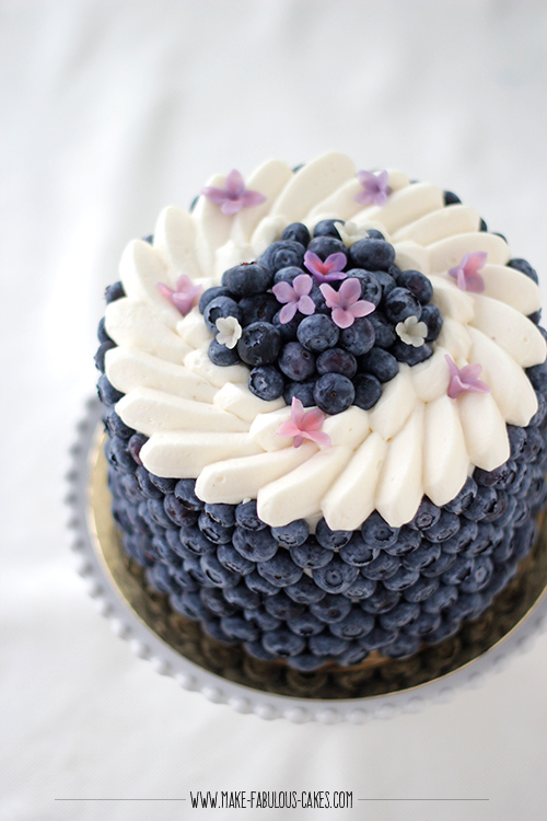 Blueberry Cream Cake with lots of  blueberries on the side of the cake