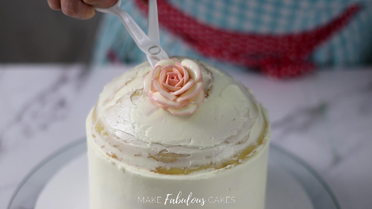 adding flower on top of the cake