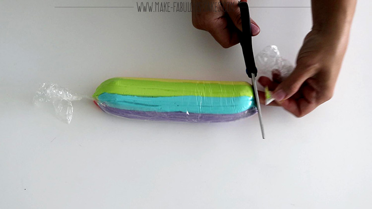 cutting one end of the rainbow frosting icing plug